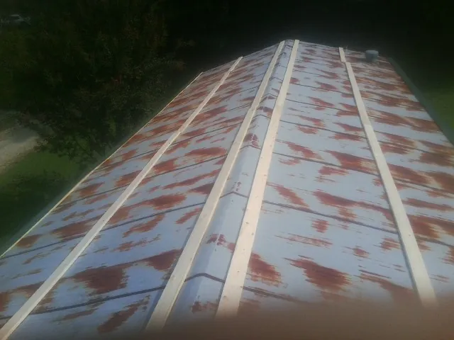Rusted metal roof panels with new wood purlins before replacement — Storm Damage Roof Repair in Mary Esther by Roofing Brothers