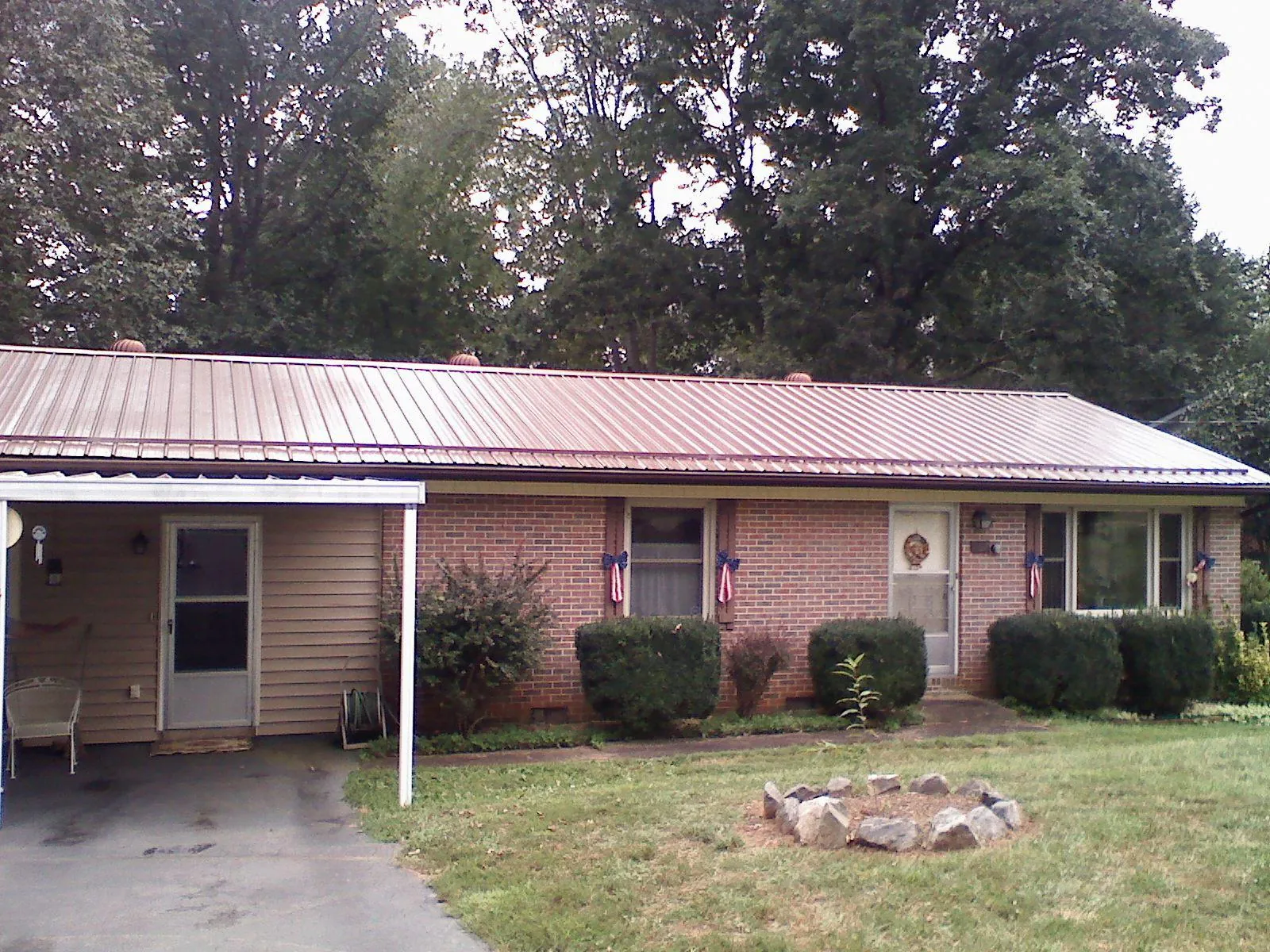Bronze metal roof and carport on a brick ranch home — Roof Repair work by our crew in Mary Esther