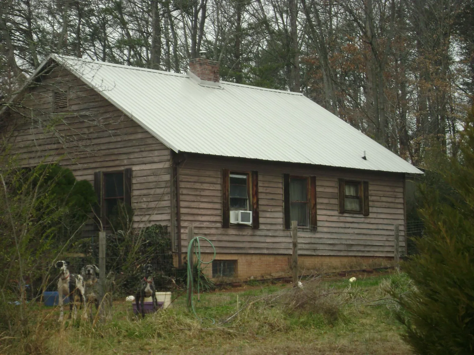 White metal roof on an old wood sided farmhouse, from a Metal Roof Installation job in Mary Esther